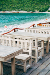 Long wooden benches and tables in a restaurant on the seaside