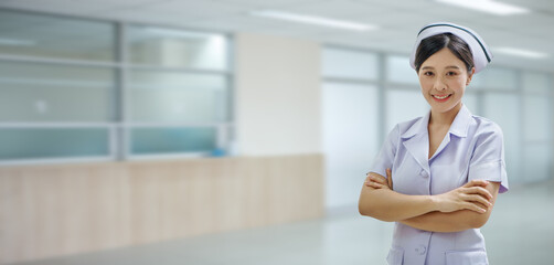 confident young asian thai nurse on indoor hospital background with copy space . banner and...
