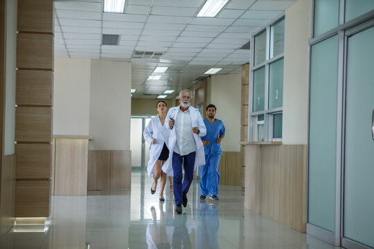 group of diverse doctor team running in hospital corridor during emergency - Powered by Adobe