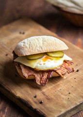 egg and bacon sandwich with pickles and gouda cheese