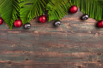 Christmas pine leaf with red bauble decoration on wooden table