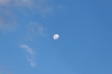 Waning gibbous moon on blue sky.