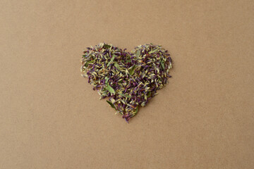 Heart shape made of dry green grass, leaves and purple clover flowers. Creative Valentine's Day card - Powered by Adobe