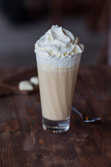 Iced milk coffee with whipped cream in a tall glass