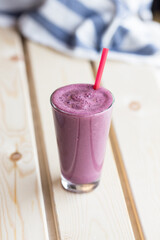 Iced blueberry milkshake smoothie in a tall glass