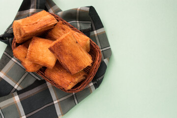 Traditional fried yucas from Latin countries in a basket with a green background