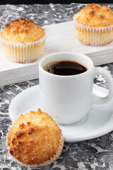 A cup of coffee served with delicious queijadinha.