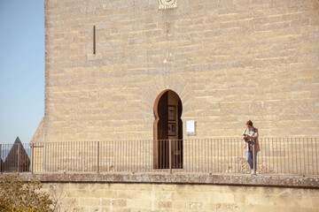 Young Hispanic traveler lady at Almodovar del Rio castle of Muslim origin in Cordoba, Spain