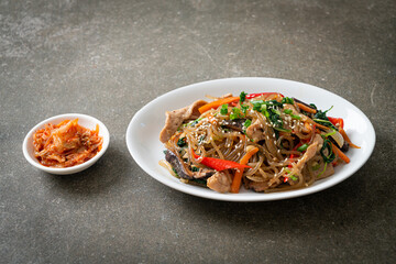 japchae or stir-fried Korean vermicelli noodles with vegetables and pork topped with white sesame