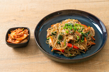 japchae or stir-fried Korean vermicelli noodles with vegetables and pork topped with white sesame