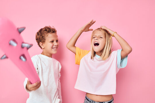 Cheerful boy and girl rubber pink baton toy fun