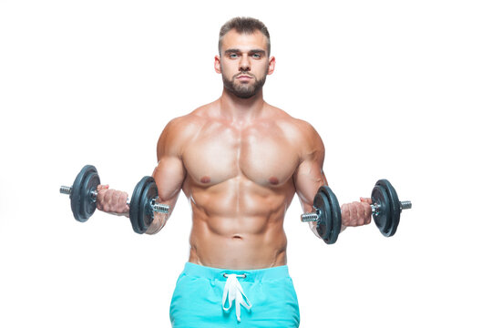 Sexy athletic man is showing muscular body with dumbbells standing with his head down, isolated over white background