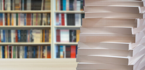 book pages stacked in front of blurred library background