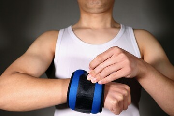 Fototapeta na wymiar 腕に重りを付ける日本人男性