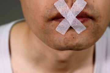 口呼吸防止のテープを貼った日本人男性