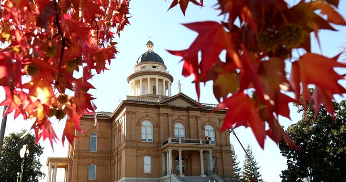 Selective focus view of liquid amber leaves framing the historic courthouse of Auburn, California, USA.