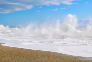 A big wave rolls over the coastline