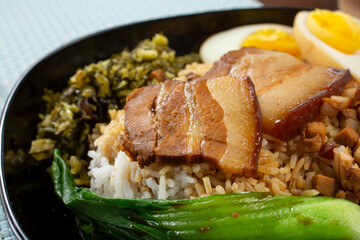 A view of a rice bowl featuring soy sauce marinated pork belly.