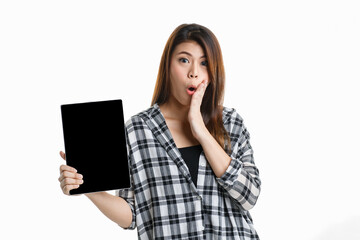 Naklejka premium Portrait studio shot of Asian happy pretty long hair female model in plaid shirt standing smiling look at camera showing presenting blank screen tablet for ads and hold thumb up on white background