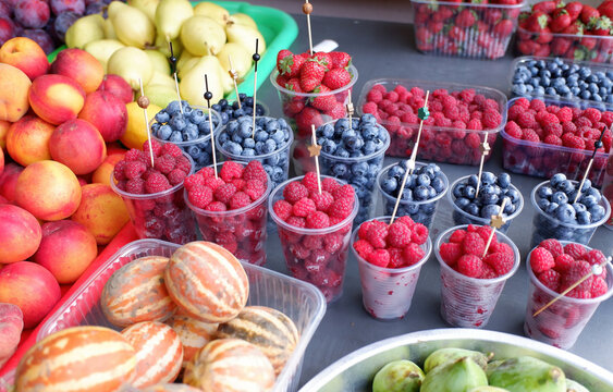 various berries and fruits on the counter of the city market.