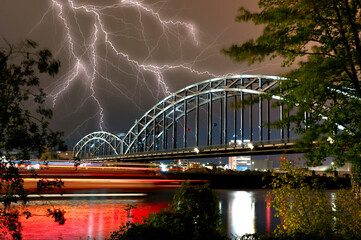 Ein Unwetter mit mehreren Blitzen am Nachthimmel über dem Main und der Deutschherrnbrücke in...
