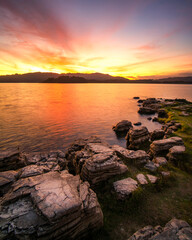 Fototapeta na wymiar Beautiful sunset view with the purple sky and white floating rock on the water for background and wallpaper