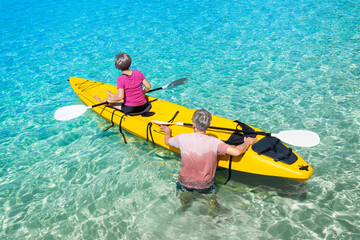 Asian senior couple on kayak in adventure travel in south east asia.