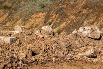Soil and debris piled up in a heap, discarded concrete blocks