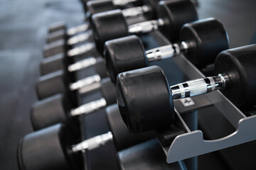 Many dumbbells on a rack in the gym