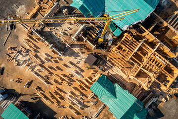 Construction site with crane of timber houses from bar. Aerial top view