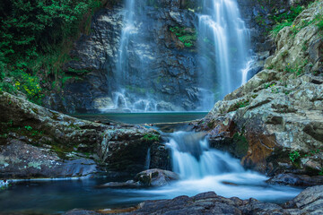 waterfall flowing streams through rocks with calm blurred water surface long exposure shot