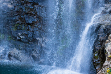 waterfall falling streams through rocks in forest at morning from flat angle