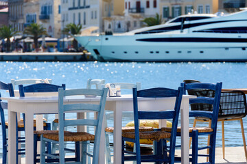 Fototapeta na wymiar A tavern without customers amid a coronavirus pandemic on the waterfront. Syros Island, Cyclades, Greece