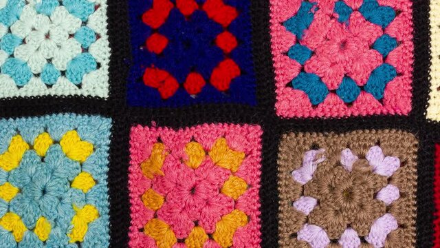 Detail of a crocheted patchwork multicolor wool blanket