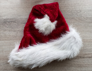 Obraz na płótnie Canvas Santa Claus hat isolated on wooden background. Merry Christmas and happy new year concept