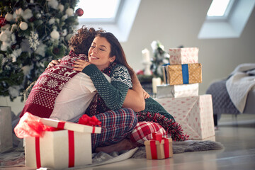 Obraz na płótnie Canvas Festive couple exchanging Christmas gifts