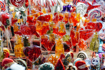 Bright red orange sweet lollipops cockerel figurines at Christmas market