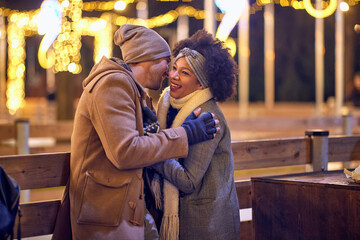 Cheerful multiethnic couple enjoying winter night