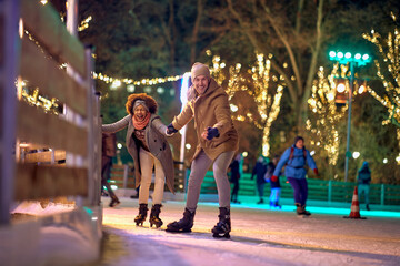 Jolly multiethnic couple enjoying ice skating