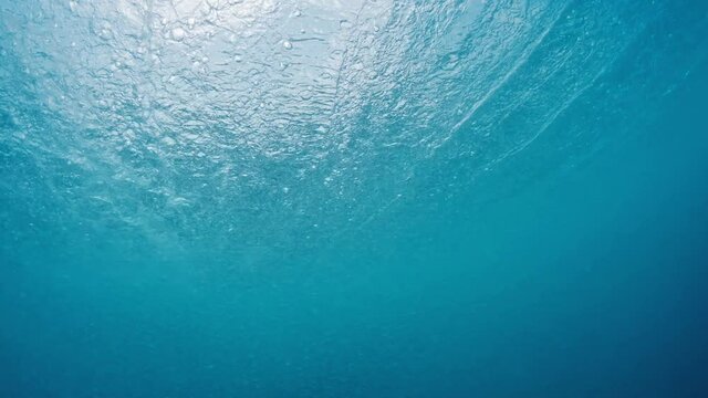 Ocean wave. Crystal clear ocean wave rolls and breaks. Underwater view of the Indian Ocean's wave breaking on the Maldivian shore