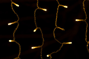 A New Year's garland of diodes hangs and burns at night in the gazebo. Close-up