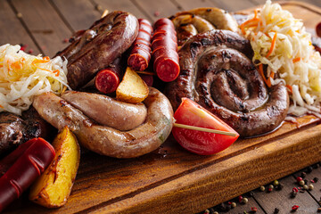 Assorted grilled sausages set on wooden serving board