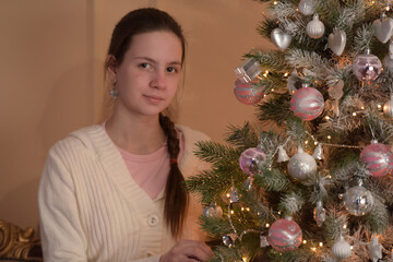 girl with christmas tree hangs toys - 475682293