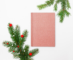 fir branches and a notebook on a white background