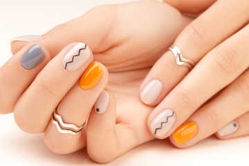 Manicured womans hands close up on beige background. Minimal spring autumn nail design