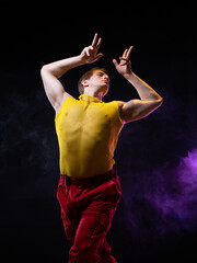 a young muscular man in a bright outfit poses in a pretentious pose, style and grotesque. An...