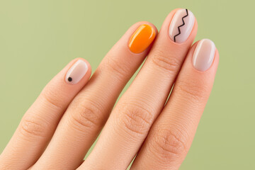 Close up womans hand with trendy minimal manicure on green background. Spring summer nail design