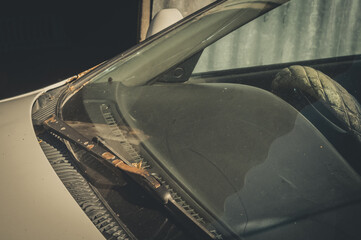 Close-up of the windshield and wipers of an old car. Dust, rust and dirt on surfaces. Selective...