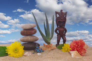 Tiki Statue on Sand With Flowers and Sea Shells