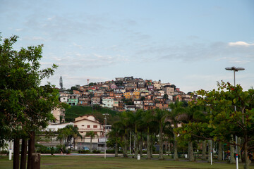 sunrise in the city park, beautiful landscape, blue sky with white clouds, several houses and palm trees.